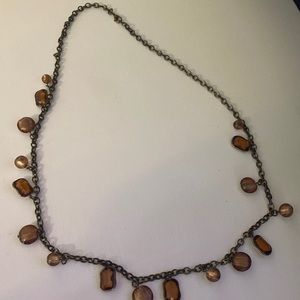 Boutique gold chain necklace with beads and gems on it